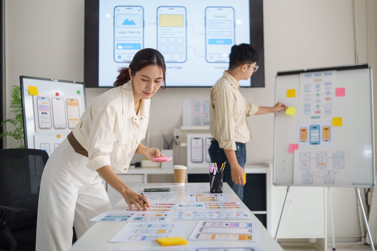 UX designer planning a mobile app interface on sticky notes